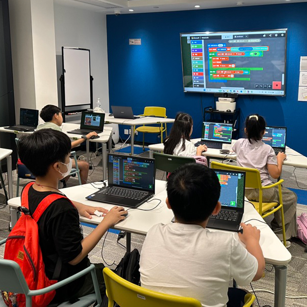 Modern gaming setup with multiple monitors showing code and game engine interfaces in a professional neon-lit studio